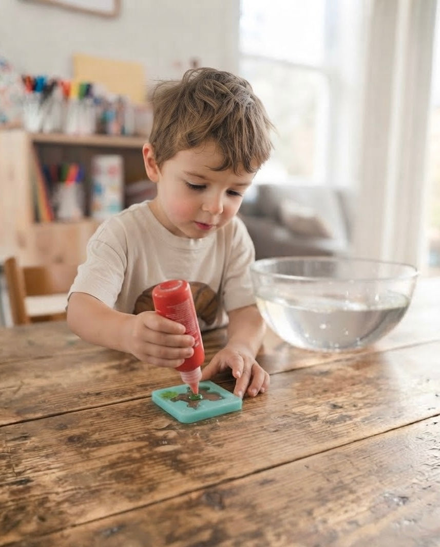 A child working independently at the kitchen table with the kit while a parent works nearby